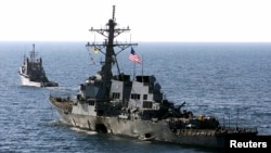 FILE - The U.S. Navy destroyer USS Cole is towed from the port city of Aden, Yemen, into open sea by the Military Sealift Command ocean-going tug USNS Catawba, Oct. 29, 2000. 