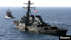 FILE - The U.S. Navy destroyer USS Cole is towed from the port city of Aden, Yemen, into open sea by the Military Sealift Command ocean-going tug USNS Catawba, Oct. 29, 2000. 