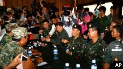 Thai army commander Tarakorn Thammavinthon, seated second right, gestures during a meeting with his Cambodian counterpart at the disputed Cambodia-Thai border in Preah Vihear Province, Cambodia, Tuesday, Nov. 12, 2013.