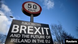 FILE - A Brexit sign is seen between Donegal in the Republic of Ireland and Londonderry in Northern Ireland at the border village of Muff, Ireland, Feb. 1, 2018.