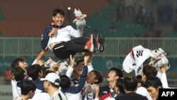 
Para pemain sepak bola Korsel mengusung Son Heung-min setelah memenangkan medali emas Asian Games dalam laga final yang digelar Bogor, 1 September 2018. (Foto: AFP)
