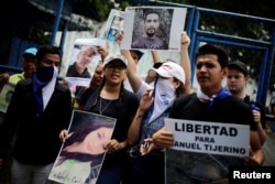 Familiares y amigos muestran imágenes de sus seres queridos durante una protesta para exigir la liberación de los manifestantes detenidos durante protestas antigubernamentales frente a una prisión en Managua, Nicaragua 2 de julio de 2018