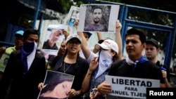 Des proches et des amis tiennent des photos de leurs proches lors d'une manifestation pour exiger la libération des manifestants détenus lors de manifestations antigouvernementales devant une prison à Managua, au Nicaragua, le 2 juillet 2018. Le panneau indique "Liberté pour Manuel Tijerino". REUTERS / Jorge Cabrera