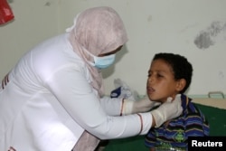 FILE - A pediatrician attends to a boy infected with diphtheria at the al-Sadaqa teaching hospital in the southern port city of Aden, Yemen, Dec. 18, 2017.