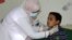FILE - A pediatrician attends to a boy infected with diphtheria at the al-Sadaqa teaching hospital in the southern port city of Aden, Yemen, Dec. 18, 2017.