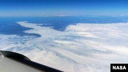 A wide view of the calving front of the Jakobshavn glacier is shown from the window of a NASA research plane. (Credit: NASA/John Sonntag)
