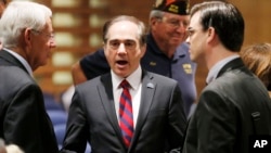 FILE - In this Dec. 14, 2015, file photo, U.S. Department of Veterans Affairs for Health Undersecretary Dr. David Shulkin (c) talks with attendees prior to testifying about the current state of the VA Medical Center in Phoenix at a Senate Veterans' Affairs Committee field hearing in Gilbert, Ariz. 