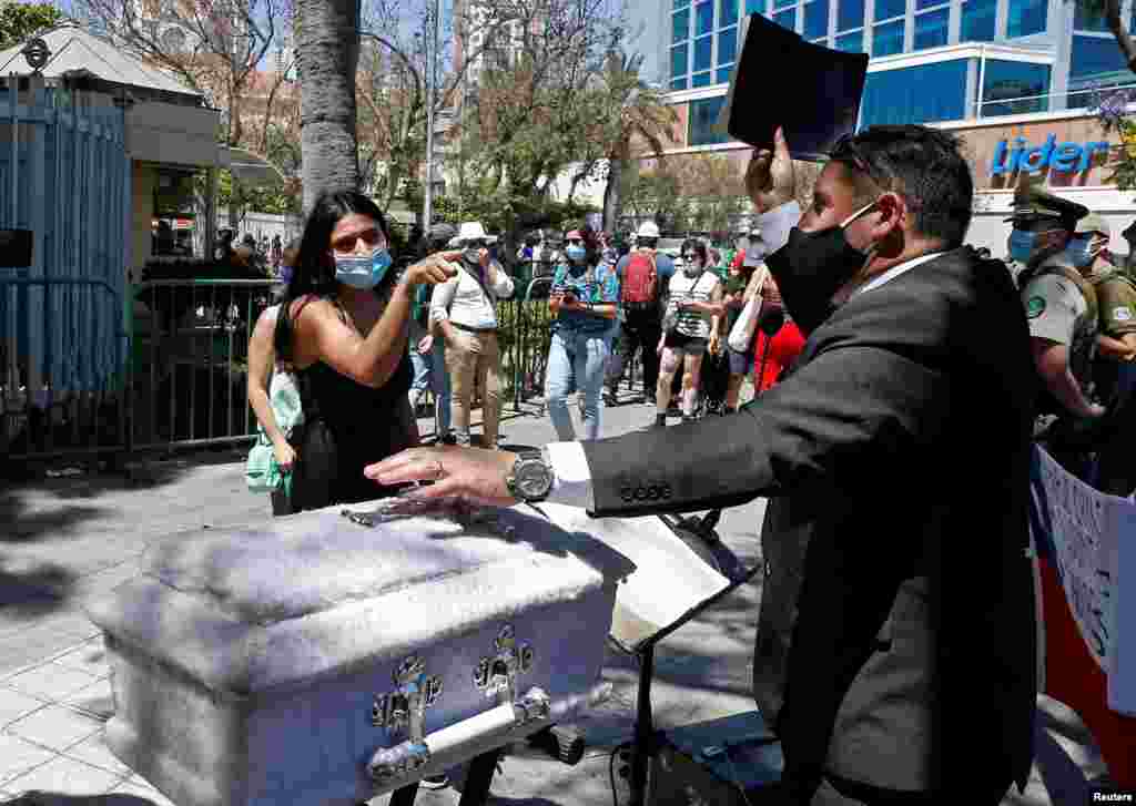 A preacher holds a bible next to an empty child&#39;s coffin as a pro-choice activist reacts, outside Congress, where lawmakers will begin to discuss a bill that decriminalizes abortion until the 14th week of gestation, in Valparaiso, Chile, Jan. 13, 2021.