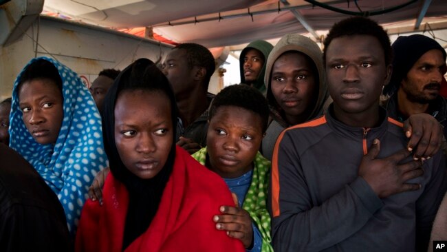 Migrants aboard the Golfo Azurro rescue vessel wait to be transferred to Italian authorities in Trapani harbor, on the Italian island of Sicily, Saturday, April 8, 2017.