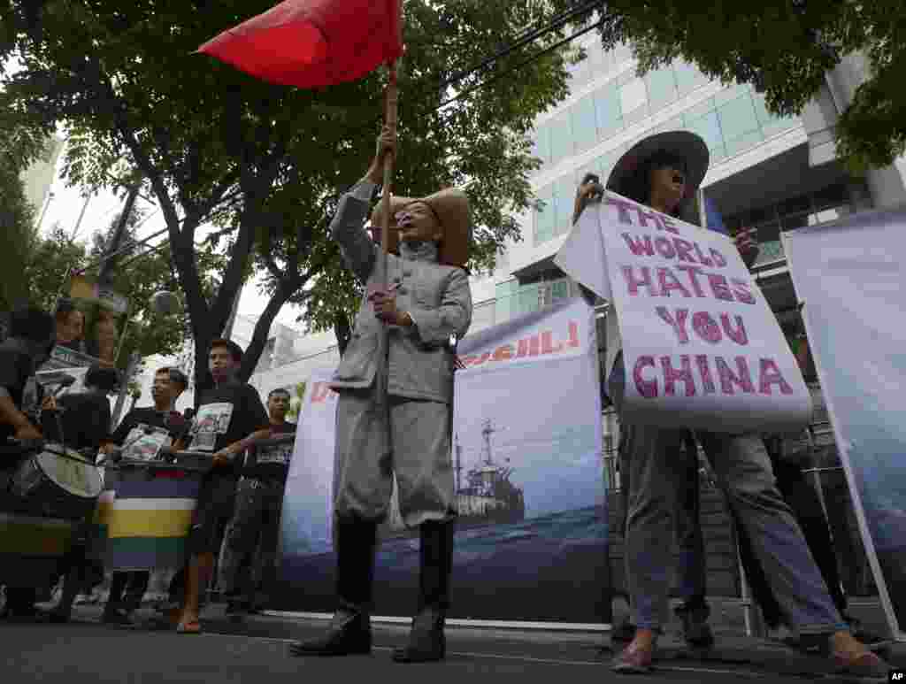 Protesters display placards while shouting slogans outside the Chinese Consulate in Manila against China&#39;s construction in a disputed area of the South China Sea, June 12, 2014.