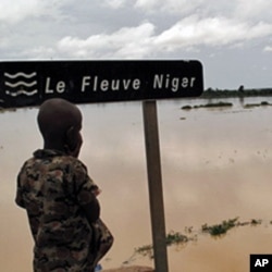 A Nigerois boy looking at the Niger River near Zinder. Aid agency Oxfam warns of a 'double disaster' for millions of people in Niger where heavy rains and flooding are compounding food shortages caused by a prolonged drought, 17 Aug 2010