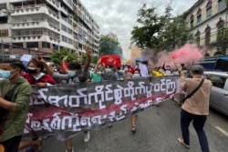 Students protest against the February military takeover by the State Administration Council as they march in Yangon, Myanmar, July 7, 2021. The sign reads, 'Hold spirit and fight. Defeat the dictatorship in any way you can.'