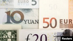 Quelques monnaies du monde dont le yuan chinois, le dollar américain, l'euro et la livre sterling.