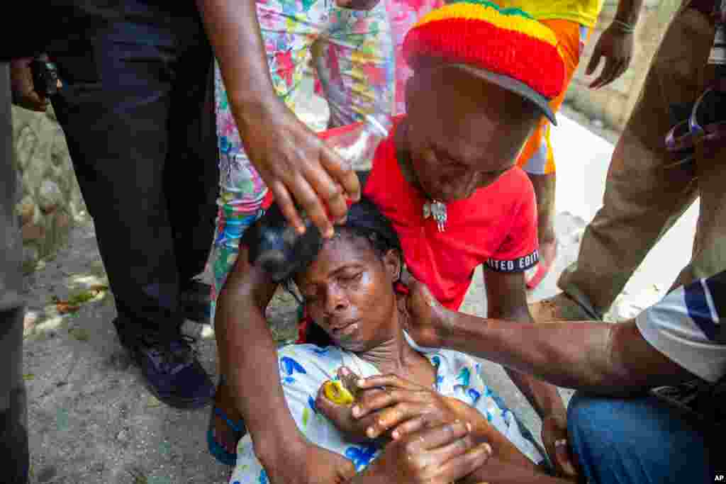 A woman who was overwhelmed by tear gas is helped by neighbors after police officers fired the substance at protesters demanding justice for Monferrier Dorval, a lawyer who was shot and killed at his home in Port-au-Prince, Haiti, Sept. 1, 2020.