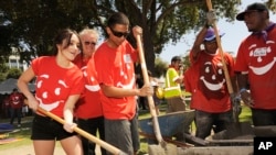 Mexican actress/singer Dulce Maria, far left, helps to build a children's playground at City of Lynwood Park, Aug. 29, 2012, in Lynwood, California.