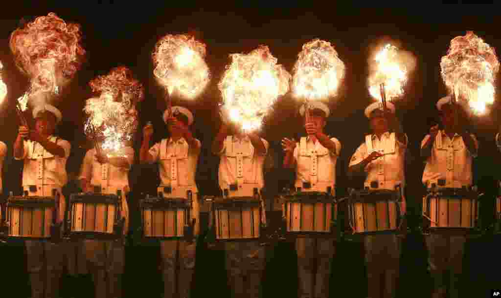 Members of the Indian Navy band perform a fire act during rehearsals for Naval Day celebrations in Mumbai.