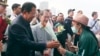 PM Kamboja Hun Sen (kiri) memberikan karangan bunga untuk seorang penumpang kapal pesiar MS Westerdam yang diperkenankan mendarat di pelabuhan Sihanoukville, Kamboja, Jumat, 14 Februari 2020. 