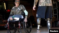 FILE - Sgt. Matt Krumwiede of the U.S. Army (L) talks to his friend Sgt. Jesse McCart at a hunting ranch outside San Antonio, Texas, November 2013.