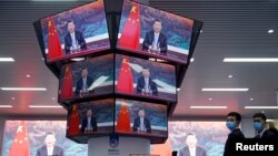 China's President Xi Jinping is seen on screens in the media center as he speaks at the opening ceremony of the third China International Import Expo (CIIE) in Shanghai, Nov. 4, 2020.