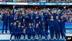 The United States team players celebrate with their gold medals during the medal ceremony after the women's soccer gold medal match between Brazil and the U.S. at the Parc des Princes, Aug. 10, 2024, in Paris