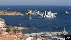 Boti za uwokozi zikikaribia meli ya abiria wa anasa Costa Concordia iliyopinduka upande mmoja kribu na kisiwa kidogo cha Isola del Giglio, Italy, January 14, 2012.