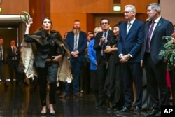 Senator Australia Lidia Thorpe (kiri), mengganggu prosesi saat Raja Charles dan Ratu Camilla dari Inggris menghadiri resepsi Parlemen di Gedung Parlemen Australia di Canberra, Senin, 21 Oktober 2024. (Lukas Coch/Pool Photo via AP)