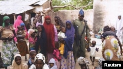 Un soldat nigérian parlant à des femmes et enfants, ex-otages de Boko Haram libérés par l'armée, Yola, Nigeria, le 29 avril 2015. 