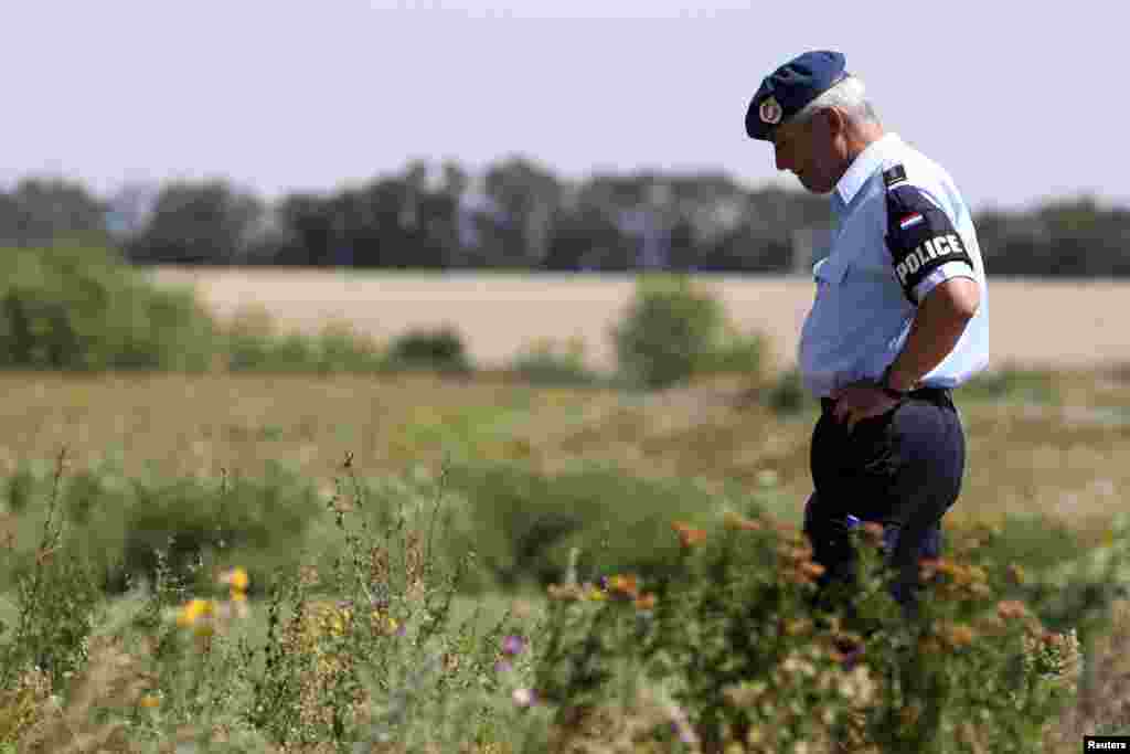 A Dutch policeman, a member of a group of international experts, visits the site where the downed Malaysia Airlines flight MH17 crashed, near the village of Hrabove (Grabovo) in Donetsk region, eastern Ukraine.