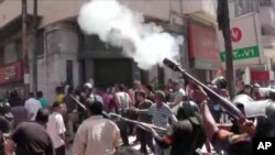 An image made from video shows police firing tear gas at supporters of ousted President Mohammed Morsi in Alexandria, Egypt, Aug. 14, 2013.