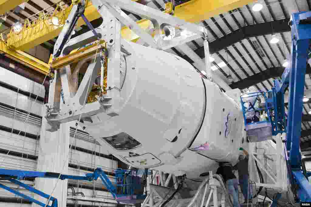 SpaceX technicians inspect a Dragon spacecraft as it is being attached to its Falcon 9 launch vehicle, September 30, 2012. (NASA/Ben Smegelsky)