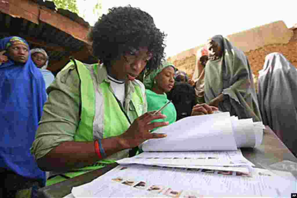 An electoral official check a voters name at a polling place in Daura, Nigeria, Saturday, April 16, 2011
