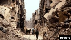 Soldiers walk past damaged buildings in Yarmouk Palestinian camp in Damascus, Syria, May 22, 2018.