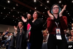 Women applaud while listening to actress Rose McGowan speak at the inaugural Women's Convention in Detroit, Oct. 27, 2017. McGowan recently went public with her allegation that film company co-founder Harvey Weinstein raped her.