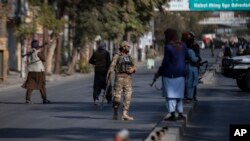 FILE - Taliban fighters block a road after an incident in Kabul, Afghanistan, Nov. 2, 2021.