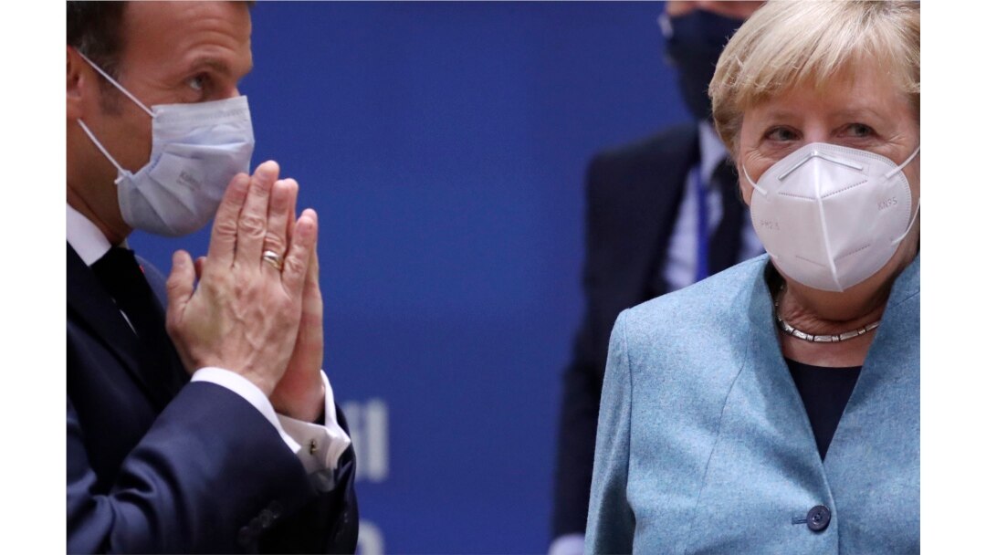 Presiden Perancis Emmanuel Macron (kiri) berbincang dengan Kanselir Jerman Angela Merkel menjelang berlangsungnya pertemuan meja bundar pada KTT Uni Eropa di gedung Dewan Eropa di Brussel, Kamis, 15 Oktober 2020.