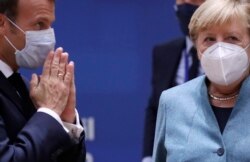 Presiden Perancis Emmanuel Macron (kiri) berbincang dengan Kanselir Jerman Angela Merkel menjelang berlangsungnya pertemuan meja bundar pada KTT Uni Eropa di gedung Dewan Eropa di Brussel, Kamis, 15 Oktober 2020.