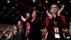 Women applaud while listening to actress Rose McGowan speak at the inaugural Women's Convention in Detroit, Oct. 27, 2017. McGowan recently went public with her allegation that film company co-founder Harvey Weinstein raped her. 