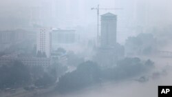 The city skyline is shrouded by a layer of mist after a torrential rain in Pyongyang, July 22, 2013.