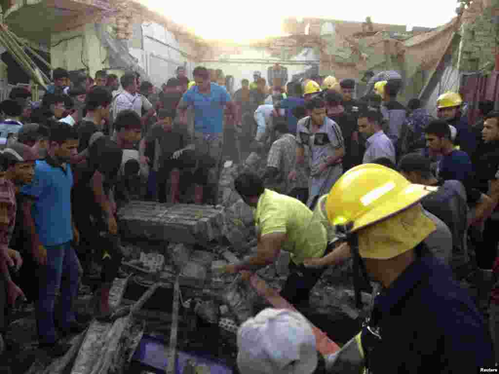 Firefighters and people gather at the site of a car bomb attack in Kut city, Iraq, July 14, 2013.