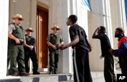 Manifestantes gritan a oficiales de policía mientras marchan por el centro de la ciudad después que una corte absolvió de culpa a un policía acusado de matar a un hombre negro en 2011. Sept.15, 2017.