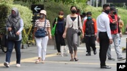 Para pejalan kaki mengenakan masker sebagai antisipasi terhadap wabah virus Covid-19 di Jakarta Senin, 12 Oktober 2020. (AP Photo / Achmad Ibrahim)