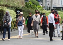 Warga mengenakan masker di sebuah jalan di tengah pandemi Covid-19 di Jakarta (foto: ilustrasi).