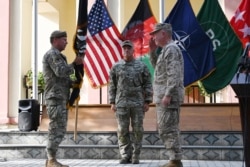 Jenderal Kenneth McKenzie (kanan), kepala Komando Pusat AS, memberi hormat saat menerima bendera dari komandan tertinggi pasukan koalisi AS di Afghanistan, Jenderal Austin "Scott" Miller (kiri), dalam sebuah acara resmi upacara serah terima di markas Resolute Support di Zona Hijau, Kabul, 12 Juli 2021. (AFP)