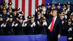 President Donald Trump waves after speaking to law enforcement officials on the street gang MS-13, July 28, 2017, in Brentwood, New York. 