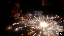 An Indian lights firecrackers to celebrate Diwali, the Hindu festival of lights, in Jammu, India, Oct. 30, 2016. Diwali, a festival of lights celebrated by Hindus, Sikhs, Jains and others in India and other countries, is starting to light up mainstream America.