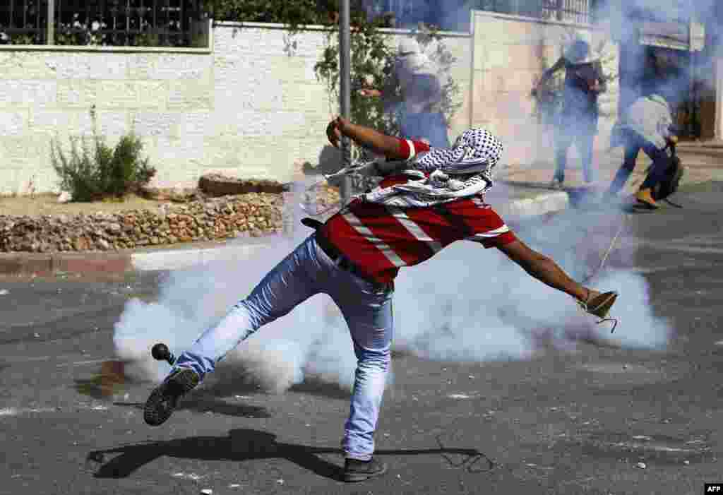 Warga Palestina melempar batu ke arah tentara Israel pada upacara pemakaman pemuda Palestina Issa al-Qatari yang tewas ditembak tentara Israel, di dekat Ramallah, Tepi Barat. &nbsp; 
