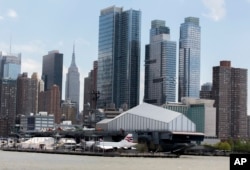 The Manhattan skyline rises behind the Intrepid Sea, Air & Space Museum in New York, May 2, 2017.