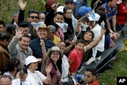 People cheer as they wait for Pope Francis to pass along the road between the airport and the Nunciatura in Bogota, Colombia, Sept. 6, 2017.