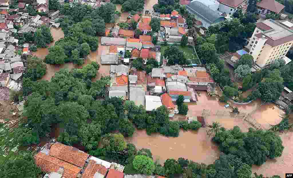 نیشنل بورڈ فار ڈیزاسٹر مینیجمنٹ، انڈونیشیا کی جانب سے یکم جنوری کو جکارتہ شہر کی جاری ہونے والی تصویر میں پانی میں گھرے مکانات اور عمارتوں کو دیکھا جاسکتا ہے۔&nbsp; &nbsp;