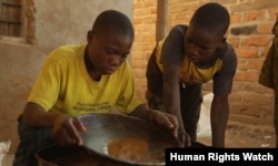 FILE - Teenage boys mix mercury and ground gold ore at a processing site in Mbeya Region, Tanzania, in this 2013 photo.